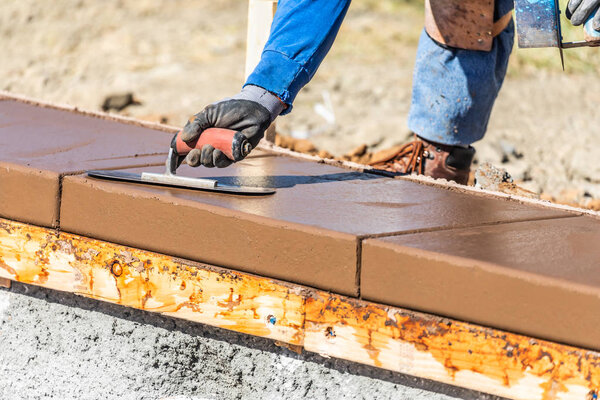 Строитель с помощью лопатки на мокрой цементной формовки справляется с новым бассейном