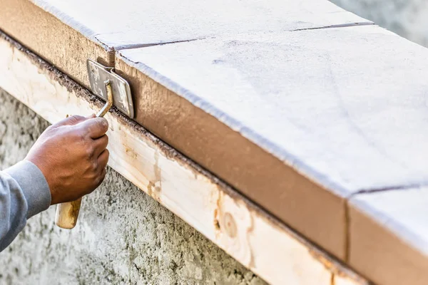 Operaio edile utilizzando mano Groover su cemento bagnato formando far fronte intorno a nuova piscina — Foto Stock