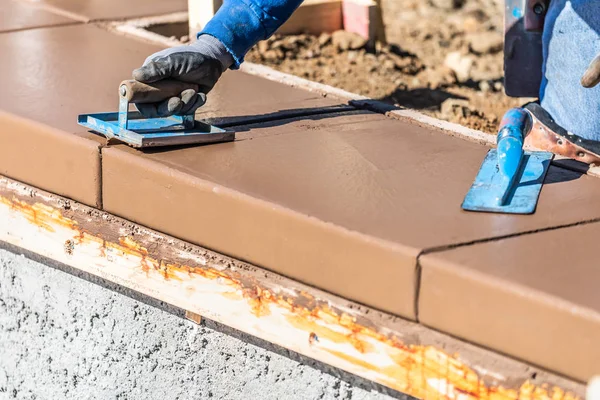 Byggarbetare med hjälp av Hand Groover på våt cement bildar hantera runt ny pool. — Stockfoto