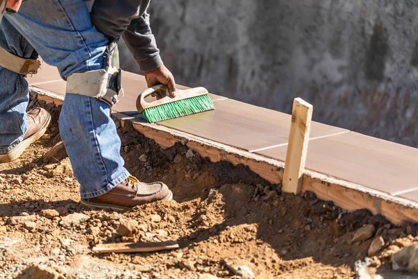 Trabajador de construcción usando cepillo en cemento húmedo formando hacer frente a la nueva piscina —  Fotos de Stock