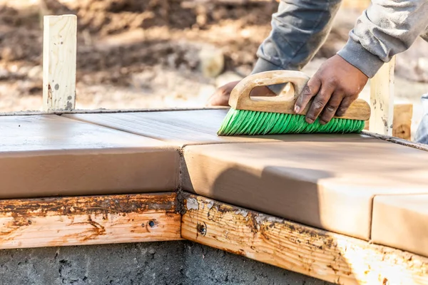 Trabajador de construcción usando cepillo en cemento húmedo formando hacer frente a la nueva piscina —  Fotos de Stock