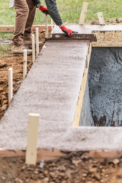 Építőipari munkások kiegyenlítése nedves cement a fa keret — Stock Fotó