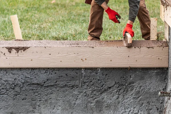 Stavební dělník Vyrovnávání vlhkého cementu do dřevěného rámu — Stock fotografie