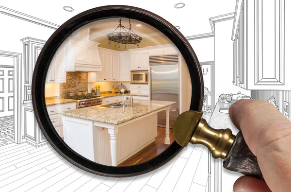Hand hållande förstoringsglas avslöjande färdiga kök bygga över ritning — Stockfoto