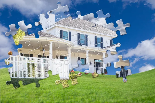 Pedaços de quebra-cabeça encaixando juntos revelando casa acabada construir sobre campo de grama — Fotografia de Stock