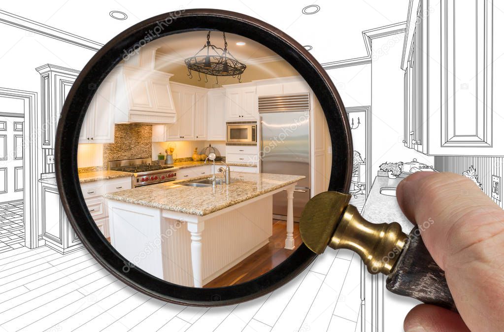 Hand Holding Magnifying Glass Revealing Finished Kitchen Build Over Drawing