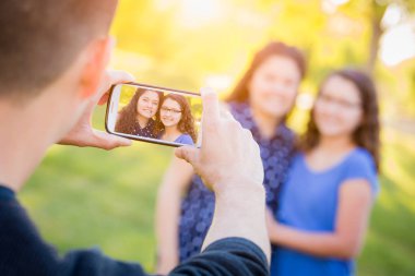 Hispanik Baba Cep Telefonu ile Anne ve Kızı Fotoğraf Çekme