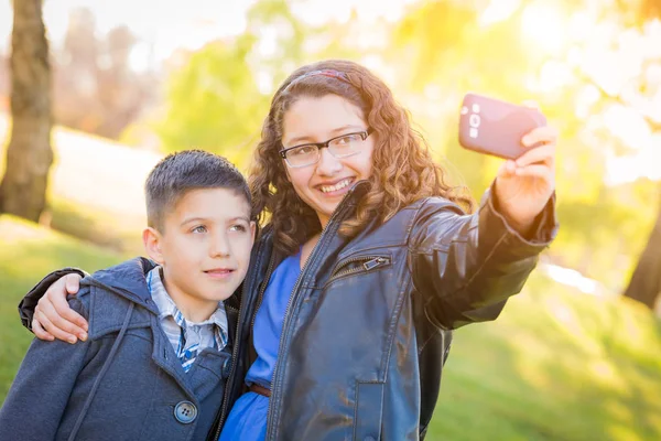 Hermano y hermana hispanos tomando selfie con teléfono celular — Foto de Stock