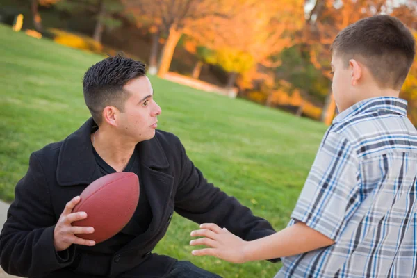 Hispânico Pai Segurando Futebol Ensino Jovem Menino — Fotografia de Stock