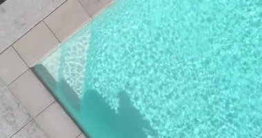 Overhead Aerial Abstract Step And Water of Swimming Pool with Shadow of Person Vacuuming 