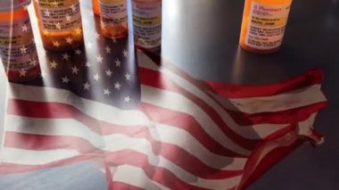 4k Slow Motion Medicine Bottles and Hapls Falling with Ghosted American Flag Waving. İlaç şişesi etiketleri hayali isimler, adresler ve stok fotoğrafçılık endüstrisi için özel olarak tasarlanmış bilgilerle sahipsiz..