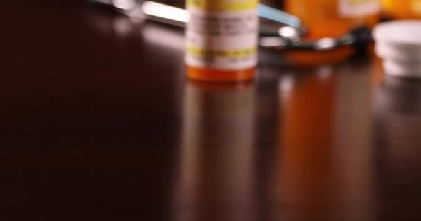 Slow Panning Non Proprietary Medicine Bottles Pills Stethoscope Dark Wood — Stock Video