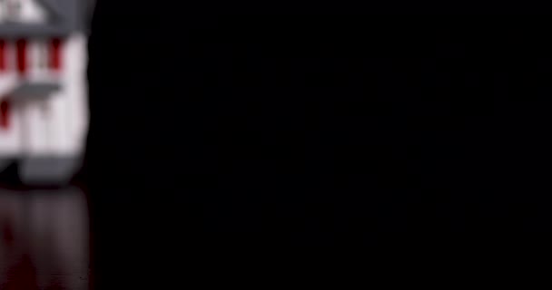 ダークウッド表面のミニチュアモデルハウスの遅いパンニング — ストック動画