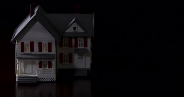 Langsames Schwenken Des Miniaturmodellhauses Auf Dunkler Holzoberfläche — Stockvideo
