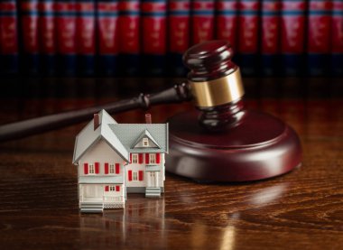 Gavel and Small Model House on Wooden Table. clipart