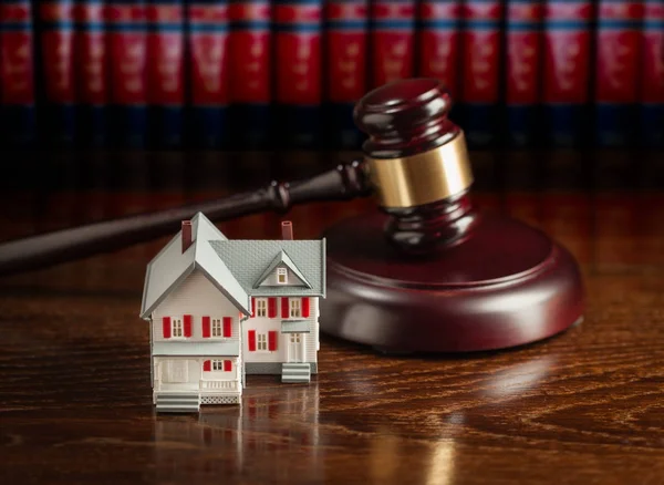 Martillo y pequeña casa modelo en mesa de madera . —  Fotos de Stock