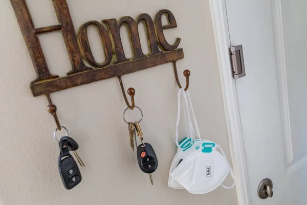 Home Key Hanger Rack Next to Door With Keys and Medical Face Mask During Coronavirus Pandemic.