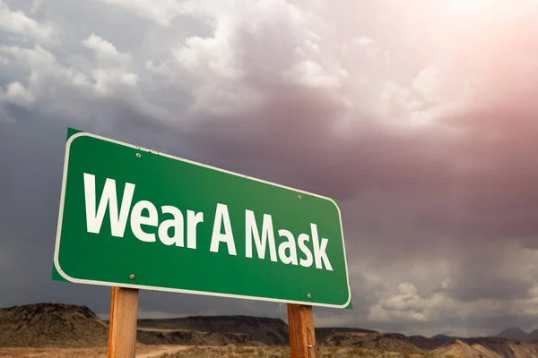 Tragen Sie Ein Maskengrünes Verkehrsschild Gegen Den Bedrohlichen Wolkenverhangenen Himmel — Stockfoto