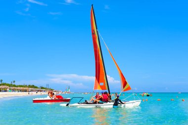 Ünlü Varadero Beach'te Küba'da bir güzel yaz günü insanlar ve renkli yelkenliler