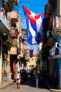 Küba bayrakları, insanlar ve Eski Havana'da yaşlı binalar ile kentsel manzara