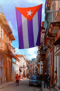 Küba bayrakları, insanlar ve Eski Havana'da yaşlı binalar ile kentsel manzara