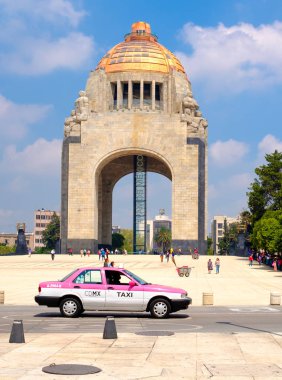 Mexico City'deki Devrim Anıtı önünde beyaz ve pembe taksi
