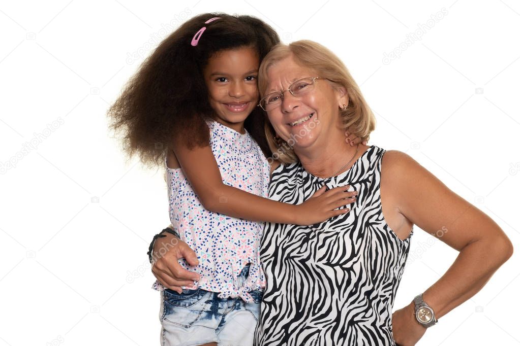 Caucasian older woman hugging her african american granddaughter - Isolated on white