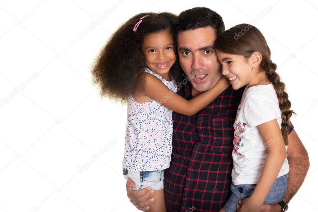 Multiracial family, Hispanic father with a funny face hugging his two mixed race daughters - Isolated on white