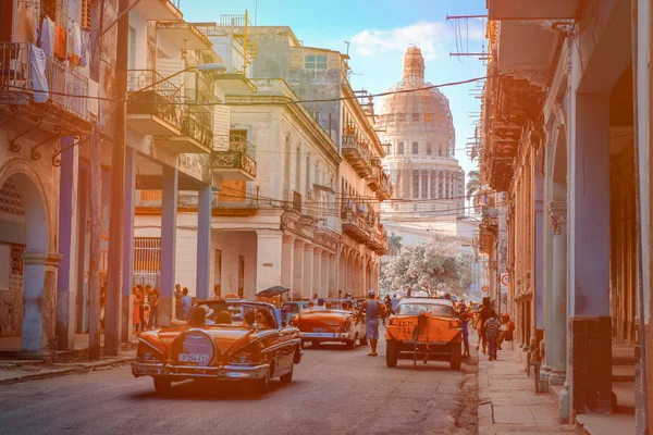 五颜六色的街道在老哈瓦那在日落与老车和国会大厦 — 图库照片