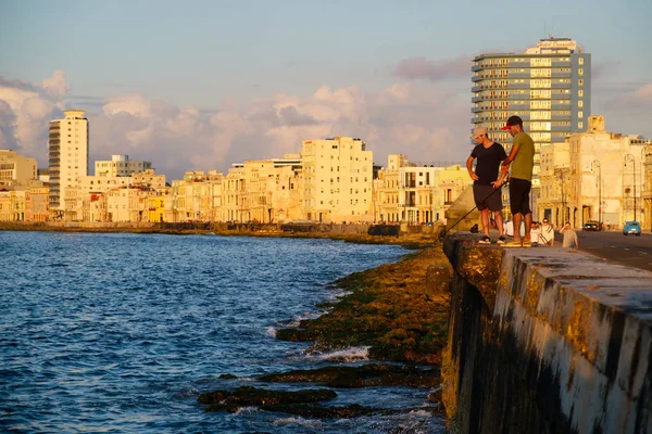 Jonge mannen vissen in Havana bij zonsondergang — Stockfoto