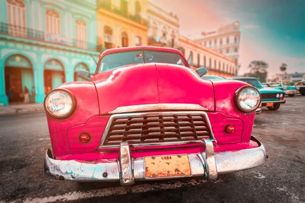 Антикварный розовый автомобиль в красочных зданиях в Старой Гаване — стоковое фото