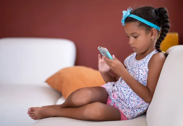 Pequena menina afro-americana usando um telefone celular — Fotografia de Stock