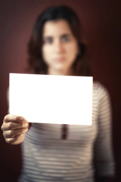 Serious young adult woman holding a blank sign — Stock Photo, Image