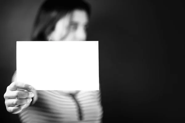 Serious young adult woman holding a blank sign — Stock Photo, Image