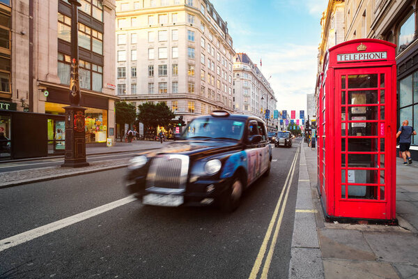 Black cab and red phone booth at The Strand in London