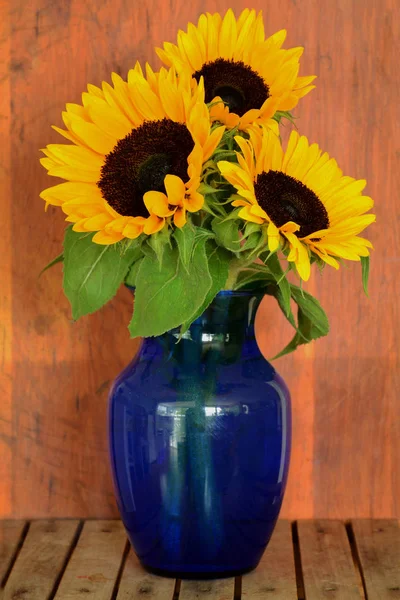 Lebendige Goldene Sonnenblumen Dunkelblauer Vase Auf Rustikalem Hintergrund Vertikalen Format — Stockfoto