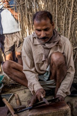 Raxaul, Bihar State, Hindistan 'daki demirci atölyesinde çalışan kimliği belirsiz Hintli adam Kasım 2013' te