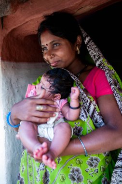 Hindistan 'ın Madhya Pradesh kentindeki Bandhavgarh Milli Parkı' nda, Tala adında küçük bir köyde çocuğuyla birlikte tanımlanamayan bir kadın.