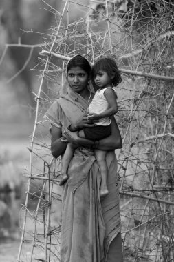 Hindistan 'ın Madhya Pradesh kentindeki Bandhavgarh Milli Parkı' nda, Tala adında küçük bir köyde çocuğuyla birlikte tanımlanamayan bir kadın.