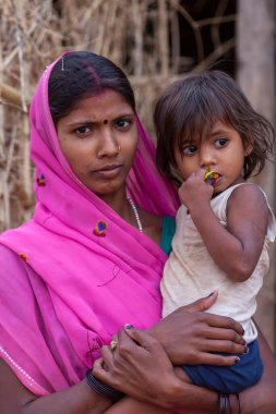 Unidentified woman with her child in a small village called Tala, at the Bandhavgarh National Park in Madhya Pradesh, India, circa April 2011 clipart