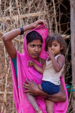 Hindistan 'ın Madhya Pradesh kentindeki Bandhavgarh Milli Parkı' nda, Tala adında küçük bir köyde çocuğuyla birlikte tanımlanamayan bir kadın.