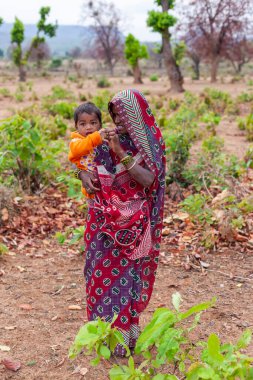 Hindistan 'ın Madhya Pradesh kentindeki Bandhavgarh Milli Parkı' nda, Tala adında küçük bir köyde çocuğuyla birlikte tanımlanamayan bir kadın.