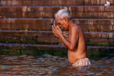 Ganj Nehri 'nin kutsal sularında yıkanan yaşlı bir adam. Varanasi, Hindistan