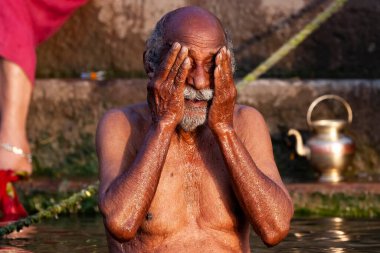 Ganj Nehri 'nin kutsal sularında yıkanan yaşlı bir adam. Varanasi, Hindistan