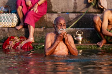 Ganj Nehri 'nin kutsal sularında yıkanan yaşlı bir adam. Varanasi, Hindistan