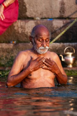 Ganj Nehri 'nin kutsal sularında yıkanan yaşlı bir adam. Varanasi, Hindistan