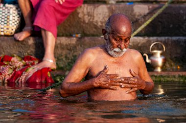 Ganj Nehri 'nin kutsal sularında yıkanan yaşlı bir adam. Varanasi, Hindistan