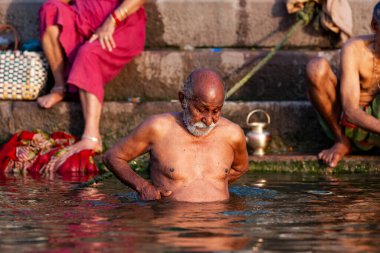 Ganj Nehri 'nin kutsal sularında yıkanan yaşlı bir adam. Varanasi, Hindistan