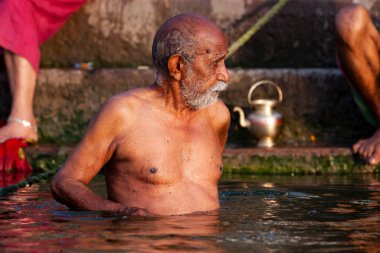Ganj Nehri 'nin kutsal sularında yıkanan yaşlı bir adam. Varanasi, Hindistan