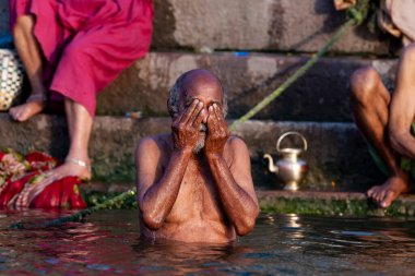 Ganj Nehri 'nin kutsal sularında yıkanan yaşlı bir adam. Varanasi, Hindistan